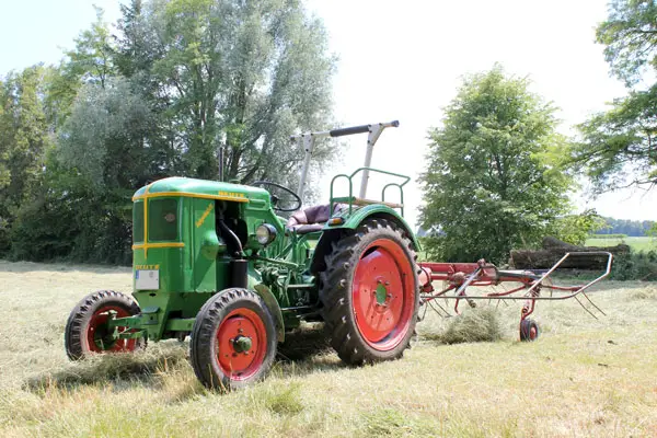 Deutz Oldtimer Traktor mit Heuwender als Hintergrundbild